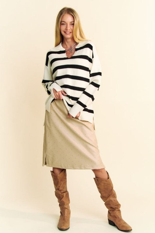 Model wearing Davi & Dani high-low striped Johnny collar sweater with a beige skirt and stylish knee-high boots.