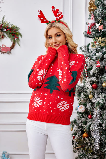 Stylish model in a festive red Christmas sweater with trees and snowflakes, perfect for holiday celebrations.