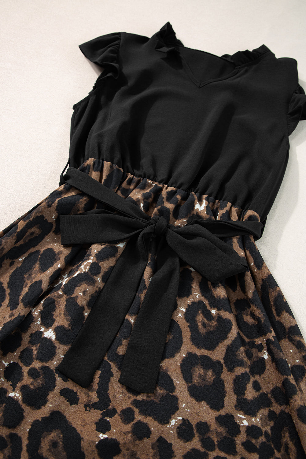 Vestido negro con estampado de leopardo y corpiño con mangas acampanadas