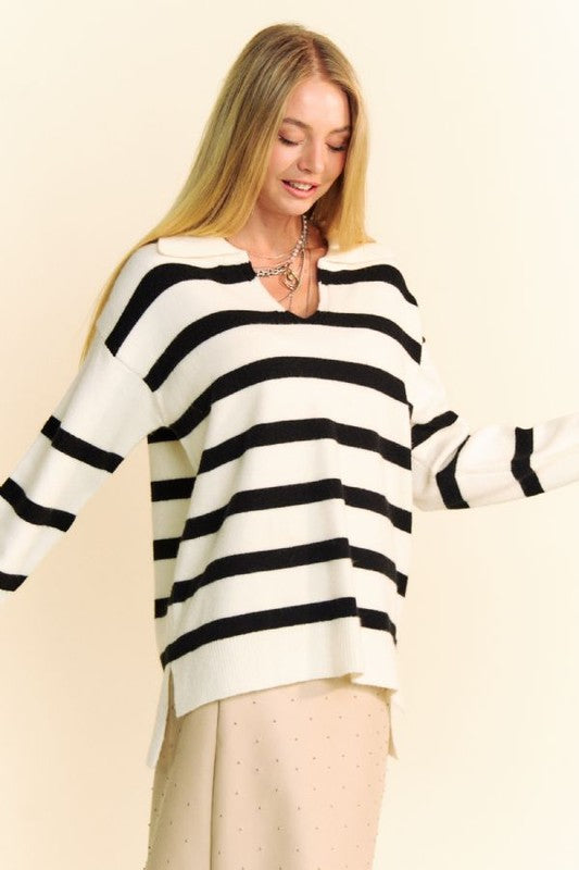 Woman wearing Davi & Dani high-low striped sweater with Johnny collar and side slits, showcasing modern style and comfort.