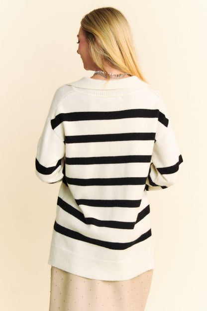 Woman wearing a Davi & Dani high-low striped sweater showing the back view with a Johnny collar and side slits.