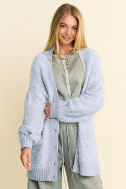 Model wearing a soft blue ribbed hem button-up long sleeve cardigan over a casual outfit, perfect for winter layering.