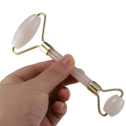 Portable crystal face roller massager held in hand, showcasing its smooth double head design for facial beauty.