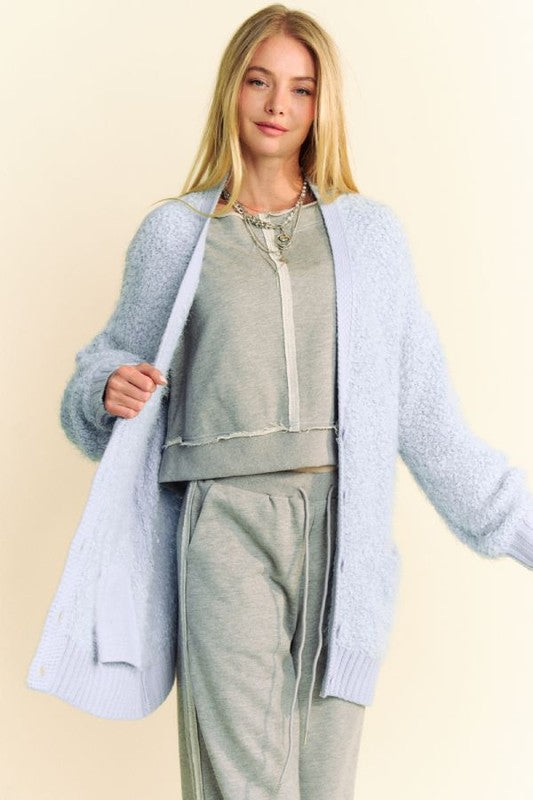 Model showcasing a light blue ribbed hem cardigan over a casual gray outfit, perfect for winter styling and online shopping.