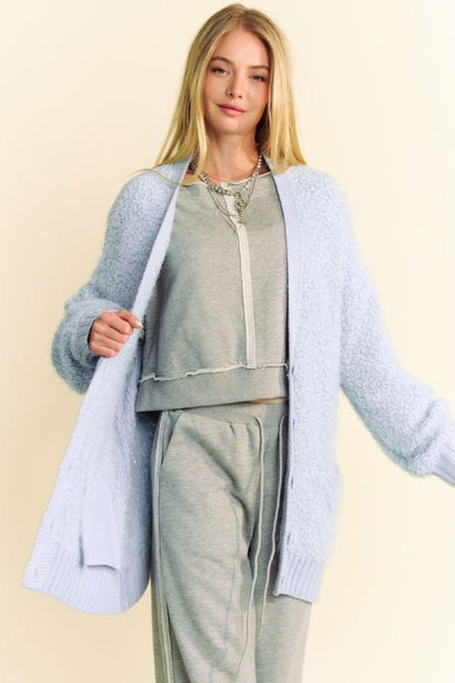 Model showcasing a light blue ribbed hem cardigan over a casual gray outfit, perfect for winter styling and online shopping.